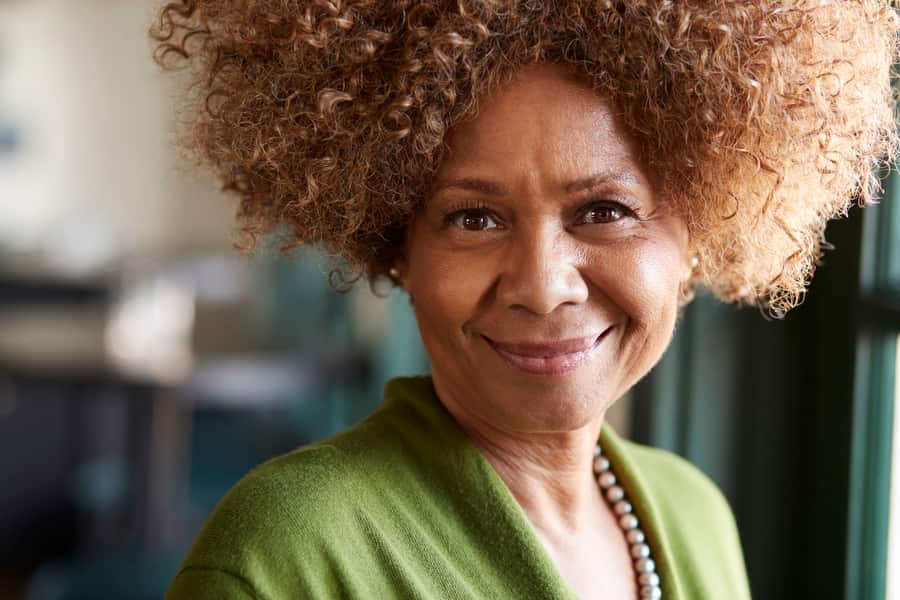 A mature woman smiling in natural light